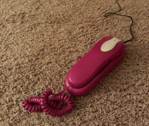 An image of a phone headset and base on a carpeted floor